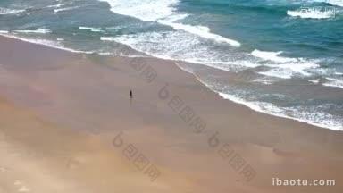 是一个安静的海滩和一个女人在海边散步